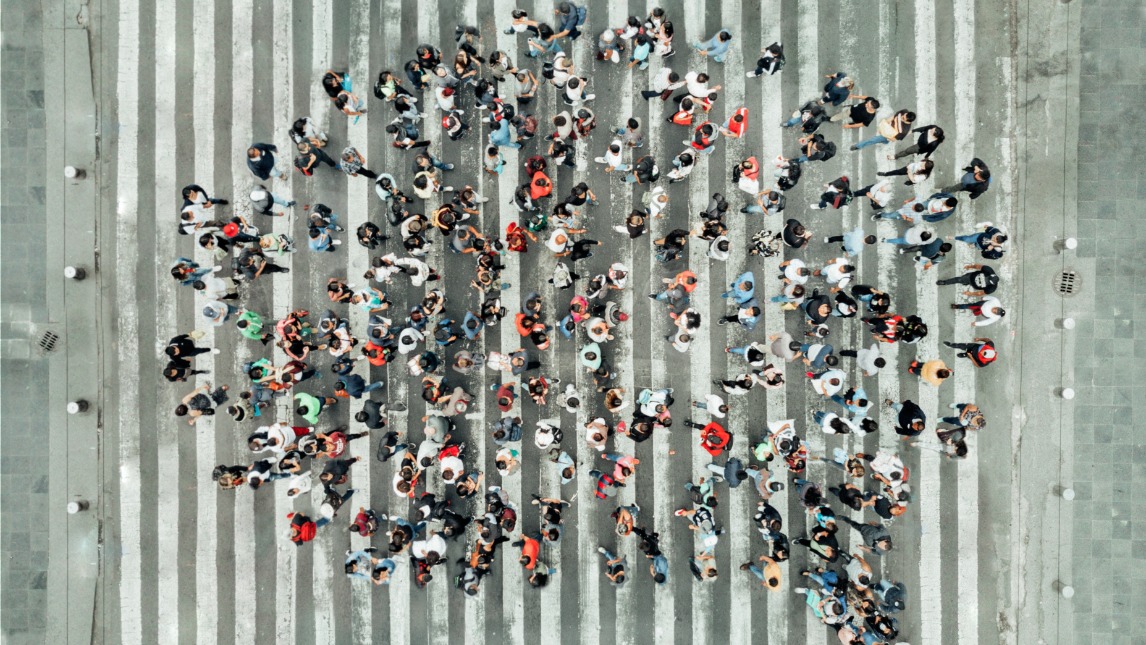 Birds eye view of people standing in the shape of a speech bubble