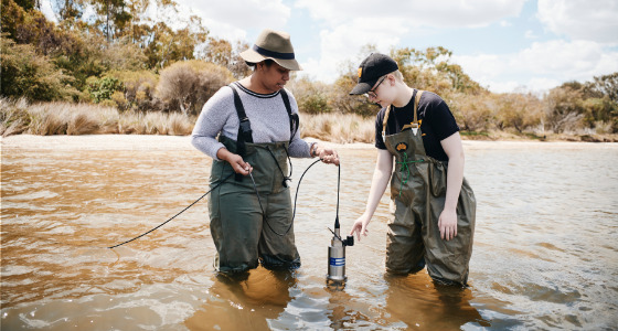 Two students conducting fieldwork in lake