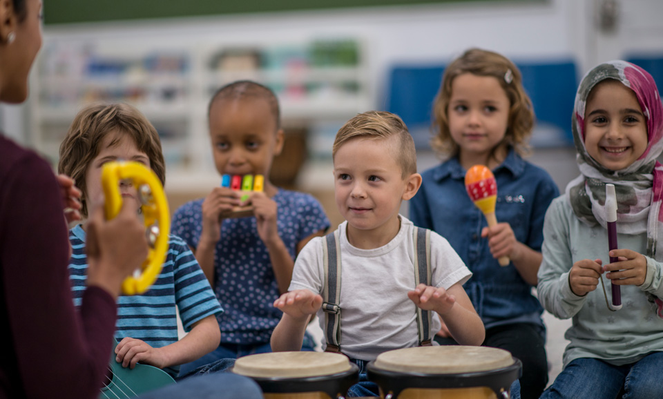 Kindergarten aged children playing musical instruments