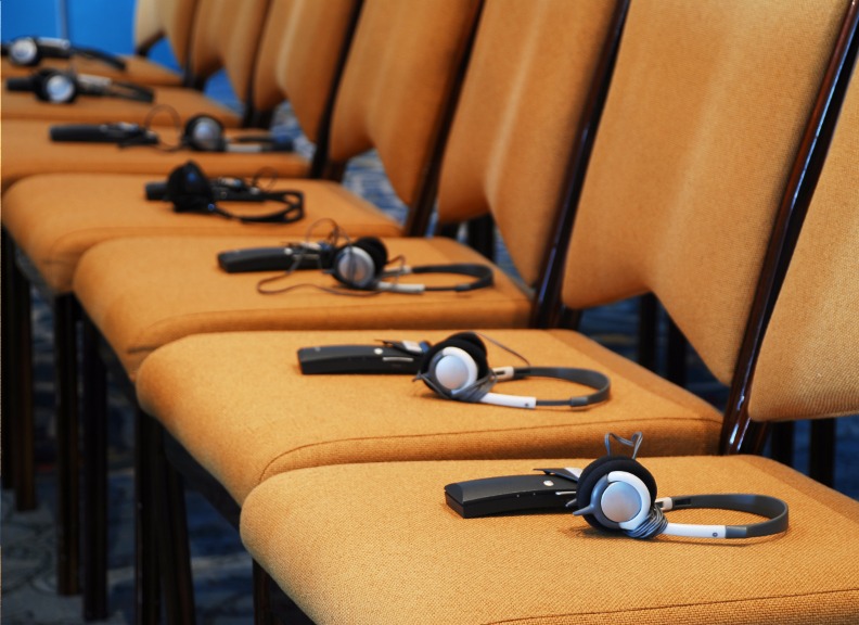 Row of seats with translation headphones on each chair