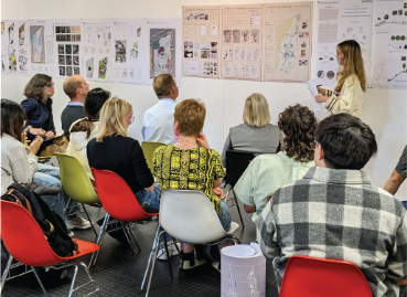 A female student presenting her work to an audience.