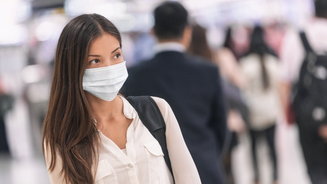 Woman in public space wearing a face mask