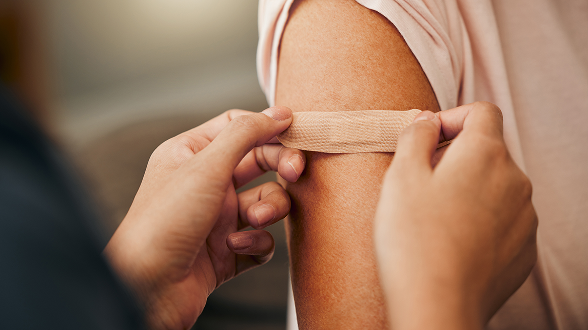 Bandaid being placed on person's arm