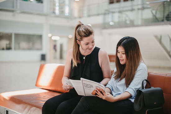 two girls reading a document