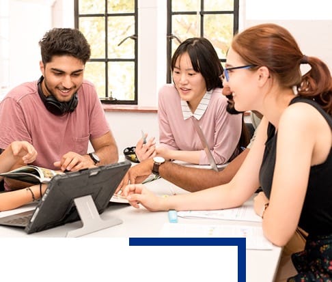 Group of students working together and looking at a book